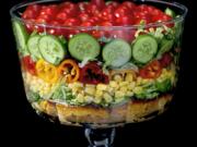 Built on a layer of savory cornbread, the summer trifle salad is made with shredded romaine lettuce, sweet corn, mini peppers, cucumbers and cherry tomatoes.