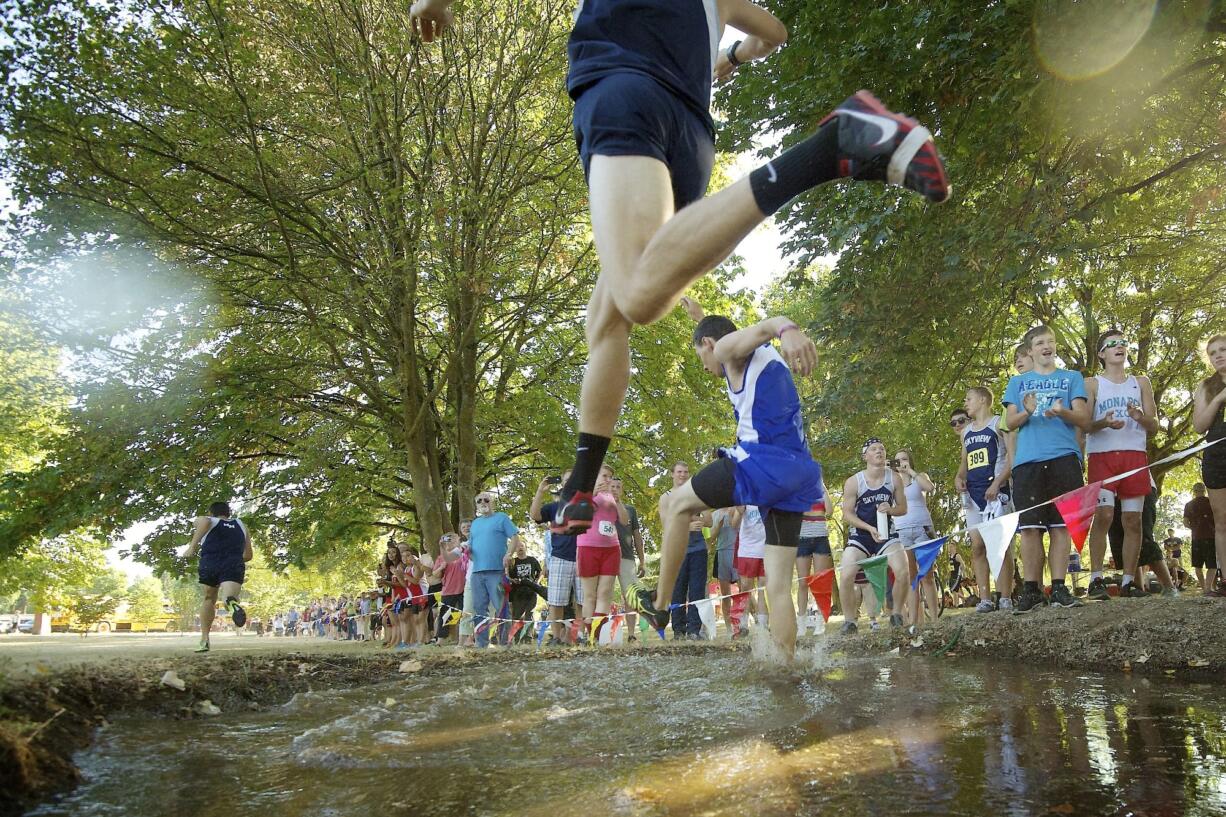 Cross Country runner fly over a steeple into a water pit during the running of the 51st Annual Run-A-Ree Friday September 7, 2012 in Vancouver, Washington.