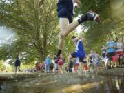 Cross Country runner fly over a steeple into a water pit during the running of the 51st Annual Run-A-Ree Friday September 7, 2012 in Vancouver, Washington.