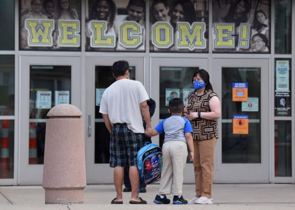 Dr. James H Naylor/CCSU Leadership Academy Principal Monica Quinones, right, explains to Thway Lay and his son, kindergartener Francis Lay, that school would not be opening Tuesday, September 8, 2020 because of a ransomeware attack on the city of Hartford&#039;s computer networks.