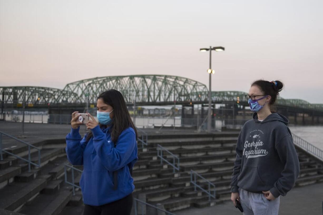 Hudson&#039;s Bay High School senior Karleena Holmquist-Juarez, left, joins classmate Jade Steele, both 17, as she snaps a photo of friends during the senior sunrise event.