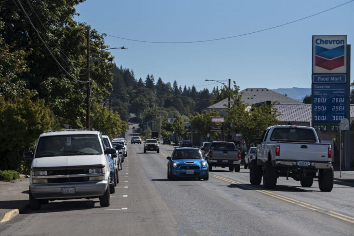 Drivers on Main Street in Battle Ground pass parked cars along both sides of the road Thursday morning.