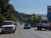 Drivers on Main Street in Battle Ground pass parked cars along both sides of the road Thursday morning.