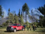 Fire crews work the Washougal River Road fire just past mile marker 5 Tuesday morning outside of Washougal. As of Tuesday morning, the fire, likely caused by a power line, was about 10 acres and 20 percent contained.