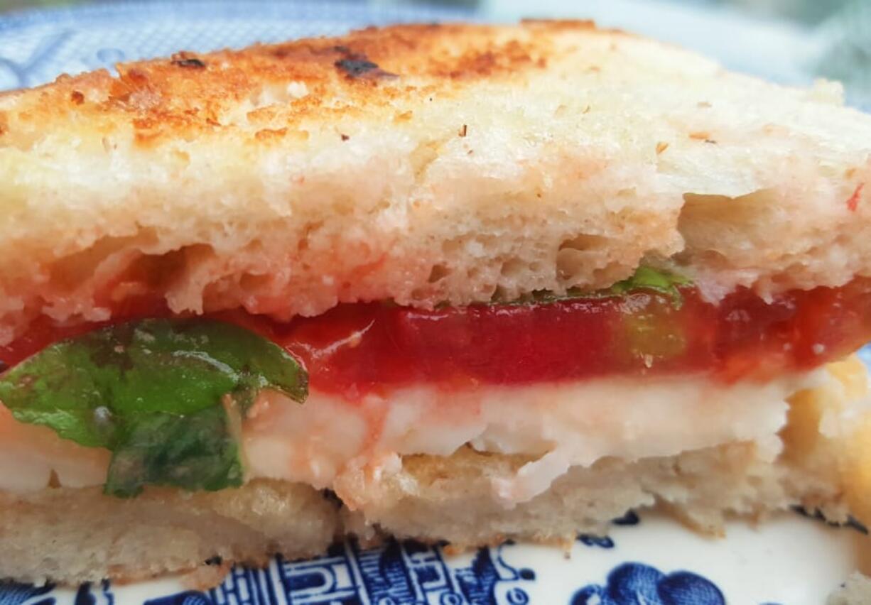 This is one of my favorite ways to eat a tomato: crusty white bread with thick slices of tomato and fresh mozzarella, plus a leaf or two of fresh basil.