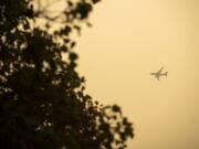 A plane passes over Fort Vancouver National Historic Site on Friday. The Portland and Seattle metro areas registered the worst air quality in the world Friday, as air quality remained in the hazardous range.