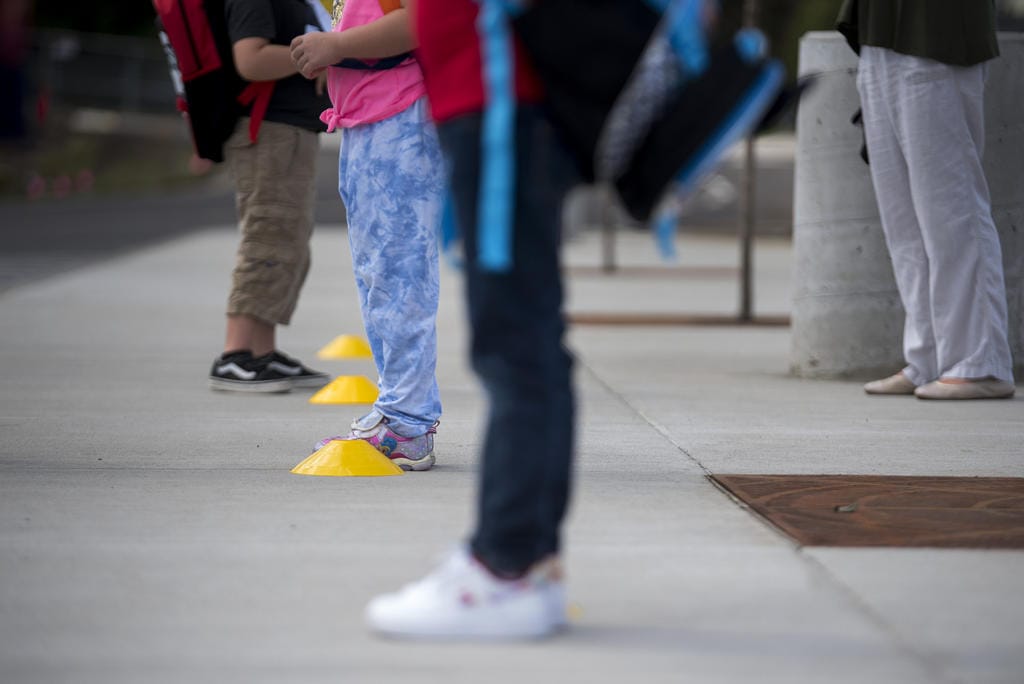 Students and teachers keep their distance as they prepare to enter the building at Sifton Elementary School on Tuesday afternoon, Sept. 22, 2020.