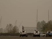 Hazardous wildfire smoke surrounds people and boats at Marine Park in Vancouver. Clark County is expected to see some relief from hazardous air by Friday.