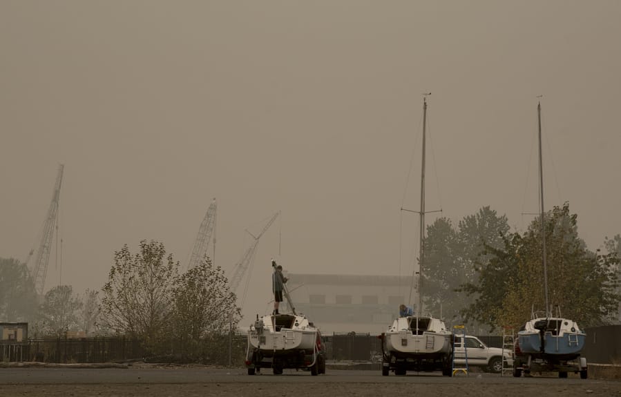 Hazardous wildfire smoke surrounds people and boats at Marine Park in Vancouver. Clark County is expected to see some relief from hazardous air by Friday.