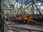 The zipper machine makes its way across the Interstate 5 Bridge to adjust the central barrier and reverse the middle lane of traffic shortly after noon Tuesday.