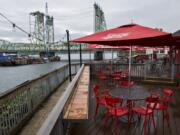 Work continues on the Interstate 5 Bridge during the trunnion replacement project, seen from the outdoor seating area at Who Song &amp; Larry&#039;s. Across the river at Jantzen Beach, restaurant owners say that business is down by roughly 50 percent because the bridge project is stopping patrons driving from Washington.