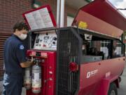 Firefighter Michael Guinett refills oxygen tanks used by fire crews in smoky situations at Station 31 in Hockinson.