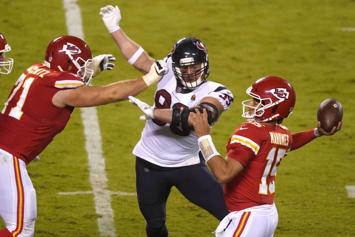 Kansas City Chiefs quarterback Patrick Mahomes (15) passes as he is pressured by Houston Texans defensive end J.J. Watt (99) in the first half of an NFL football game Thursday, Sept. 10, 2020, in Kansas City, Mo.