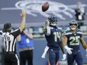 Seattle Seahawks wide receiver DK Metcalf (14) tosses the ball as he stands with running back Travis Homer (25) after Metcalf scored a touchdown against the Dallas Cowboys during the second half of an NFL football game, Sunday, Sept. 27, 2020, in Seattle.