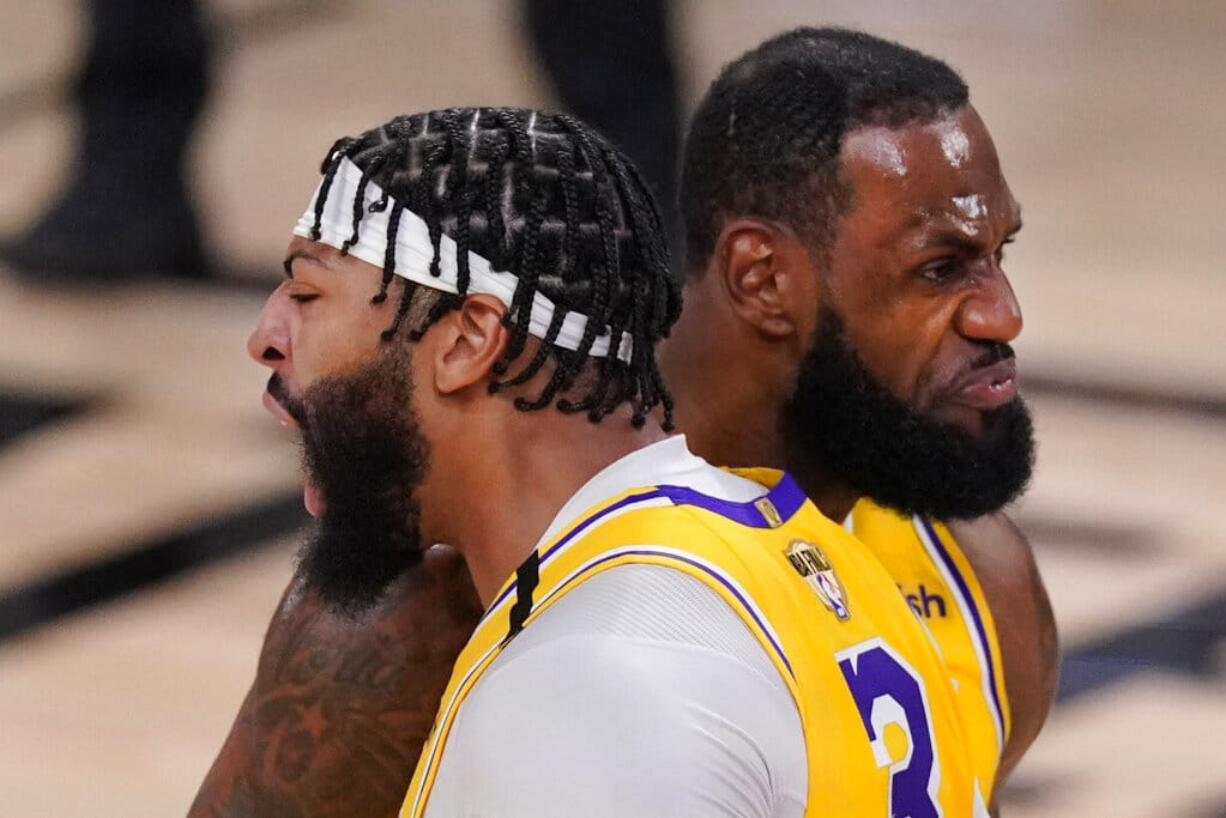 Los Angeles Lakers' Anthony Davis (3) bumps shoulders with LeBron James while celebrating after a dunk against the Miami Heat during the second half of Game 1 of basketball's NBA Finals Wednesday, Sept. 30, 2020, in Lake Buena Vista, Fla. (AP Photo/Mark J.