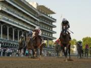 Jockey John Velazquez riding Authentic, right, crosses the finish line to win the 146th running of the Kentucky Derby at Churchill Downs, Saturday, Sept. 5, 2020, in Louisville, Ky.