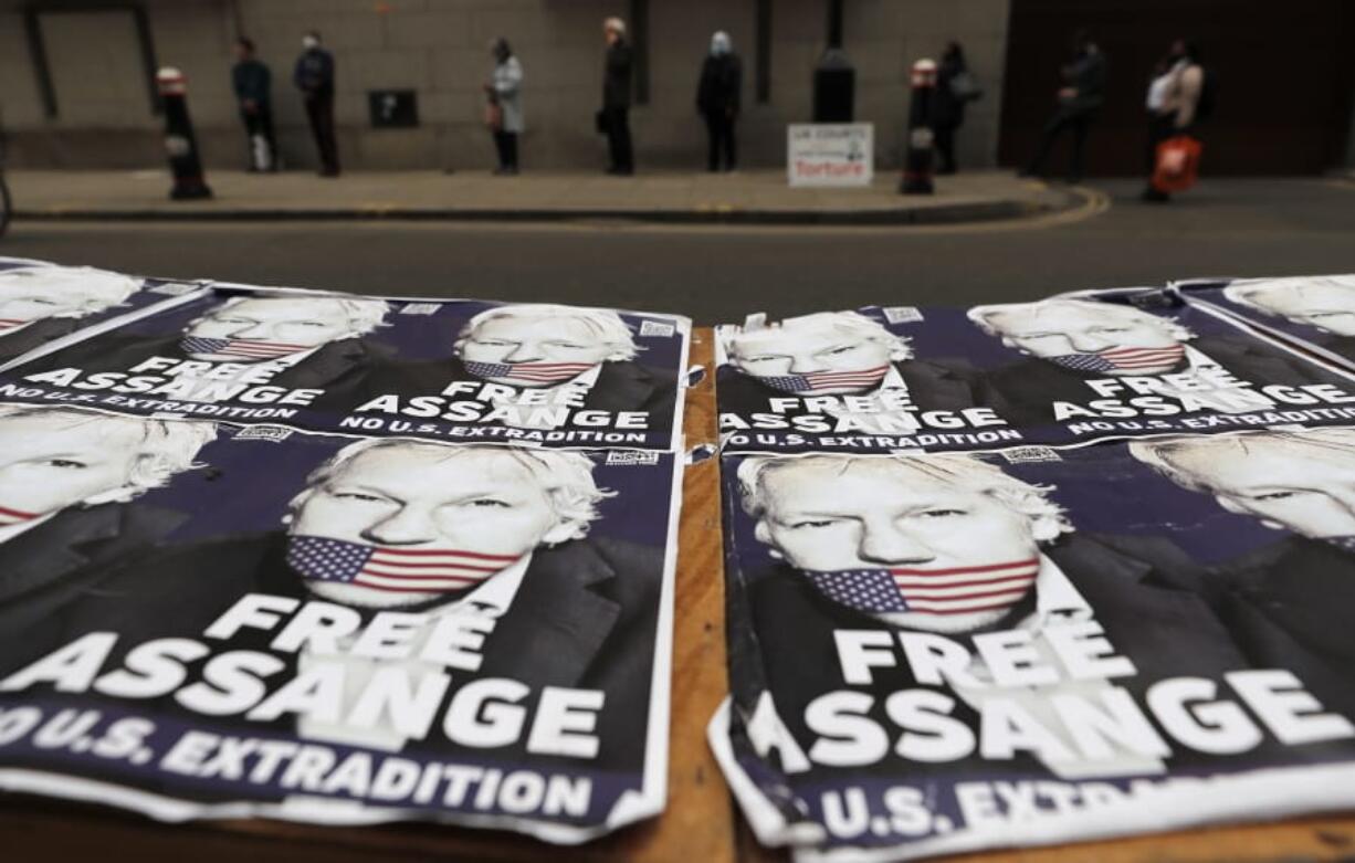 People queue at the entrance of the Old Bailey court in London, Monday, Sept. 21, 2020, as the Julian Assange extradition hearing to the US continues.