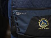 A patch is seen on the bag of Clark County Public Health Environmental Health Specialist Maggie Yaddof in January. Clark County is receiving more CARES Act funding to help cover things such as salaries for Public Health employees.