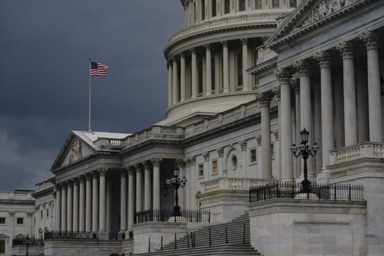 FILE - In this Aug. 3, 2020, file photo dark clouds and heavy rain sweep over the U.S. Capitol in Washington. At least a government shutdown is off the table. But as lawmakers straggle back to Washington for an abbreviated pre-election session, hopes are fading for a pandemic relief bill, or much else. (AP Photo/J.