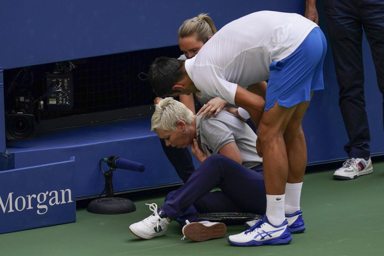 Novak Djokovic, of Serbia, checks a linesman after hitting her with a ball in reaction to losing a point to Pablo Carreno Busta, of Spain, during the fourth round of the US Open tennis championships, Sunday, Sept. 6, 2020, in New York. Djokovic defaulted the match.