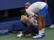 Novak Djokovic, of Serbia, checks a linesman after hitting her with a ball in reaction to losing a point to Pablo Carreno Busta, of Spain, during the fourth round of the US Open tennis championships, Sunday, Sept. 6, 2020, in New York. Djokovic defaulted the match.