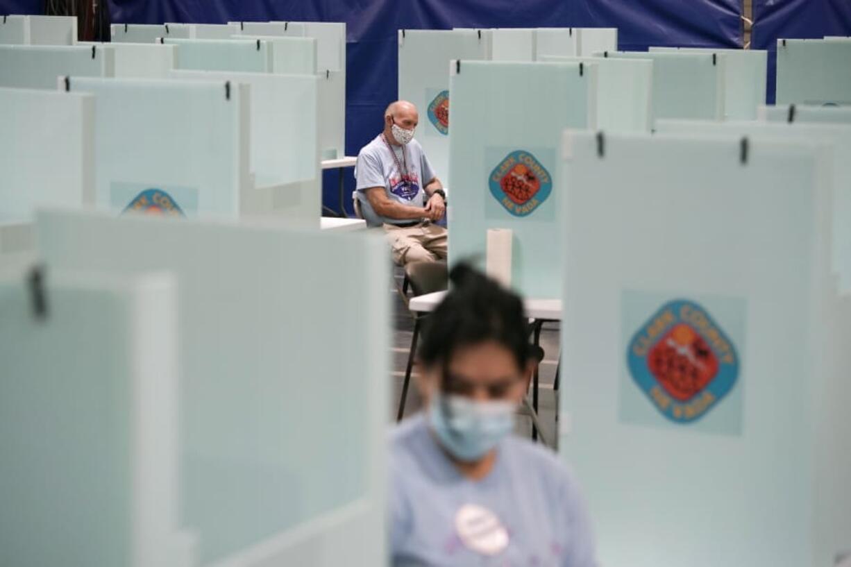 FILE - In this June 9, 2020, file photo, election workers staff one of a few in-person voting places in Las Vegas during a nearly all-mail primary election. Less than eight weeks before Nov. 3 elections, President Donald Trump&#039;s campaign is urging a federal judge in Las Vegas to block a new state law and prevent mail-in ballots from going to all active Nevada voters amid the coronavirus pandemic.