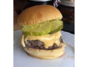 This June 2020 photo shows a cheeseburger topped with pickles in Alexandria, Va. To get the best tasting burger, try making your own  blend with better quality cuts of beef.