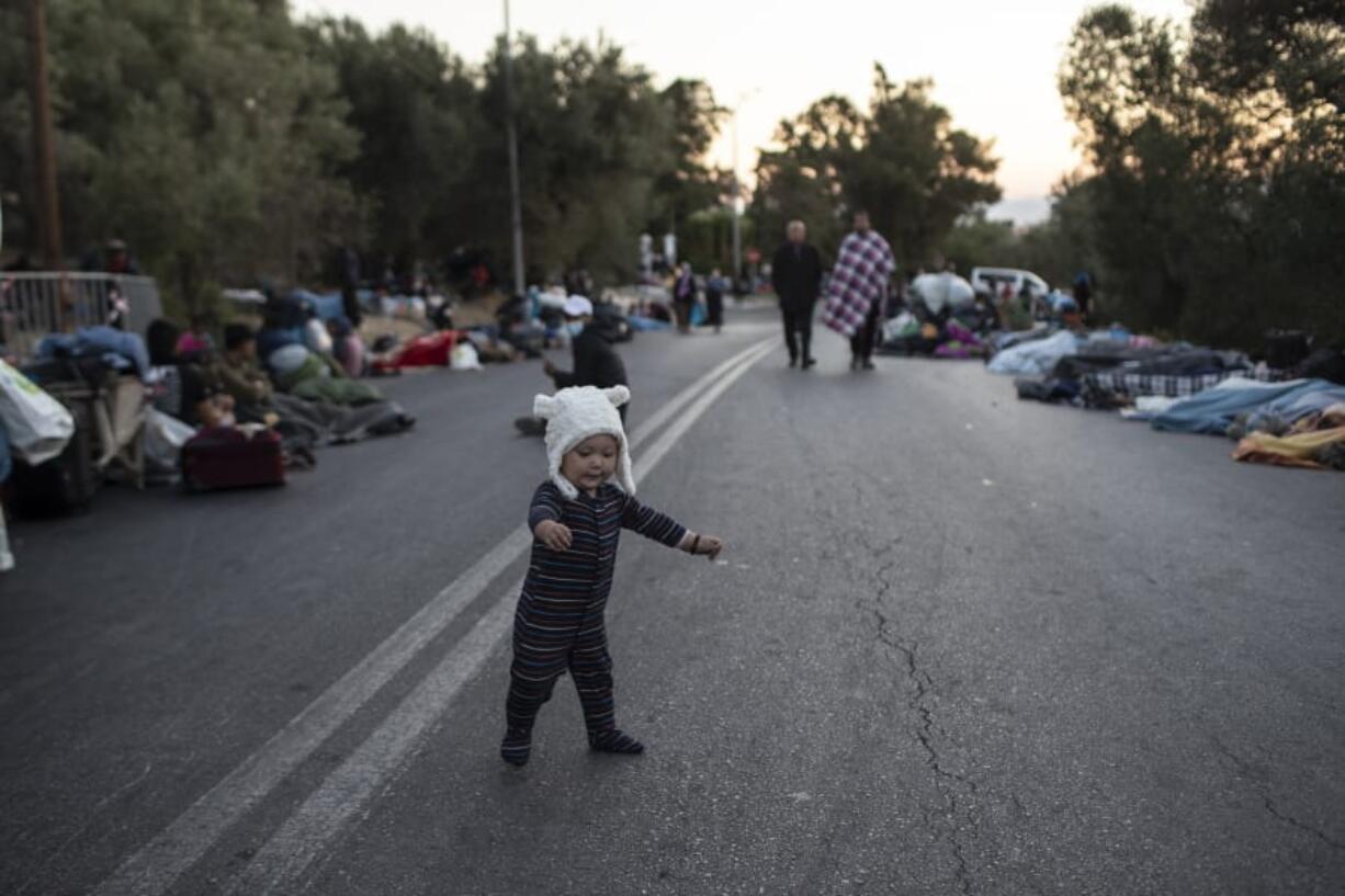 A boy tries to stand as migrants sleep on the road near the Moria refugee camp on the northeastern island of Lesbos, Greece, Thursday, Sept. 10, 2020. A second fire in Greece&#039;s notoriously overcrowded Moria refugee camp destroyed nearly everything that had been spared in the original blaze, Greece&#039;s migration ministry said Thursday, leaving thousands more people in need of emergency housing.