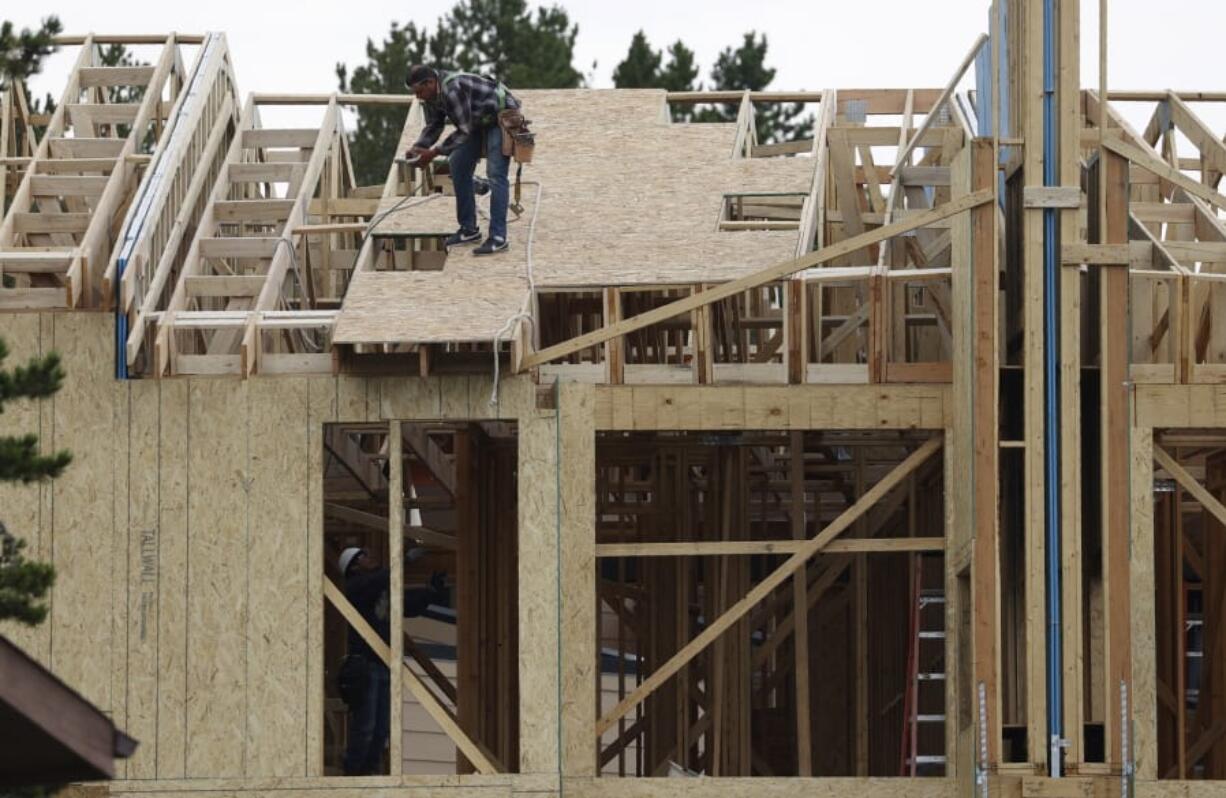 Workers toil on a multifamily dwelling Tuesday, Aug. 4, 2020, in Winter Park, Colo.   The Commerce Department reported Tuesday, Aug. 18, construction of new U.S. homes surged 22.6 percent last month as homebuilders continued to bounce back from the coronavirus pandemic.