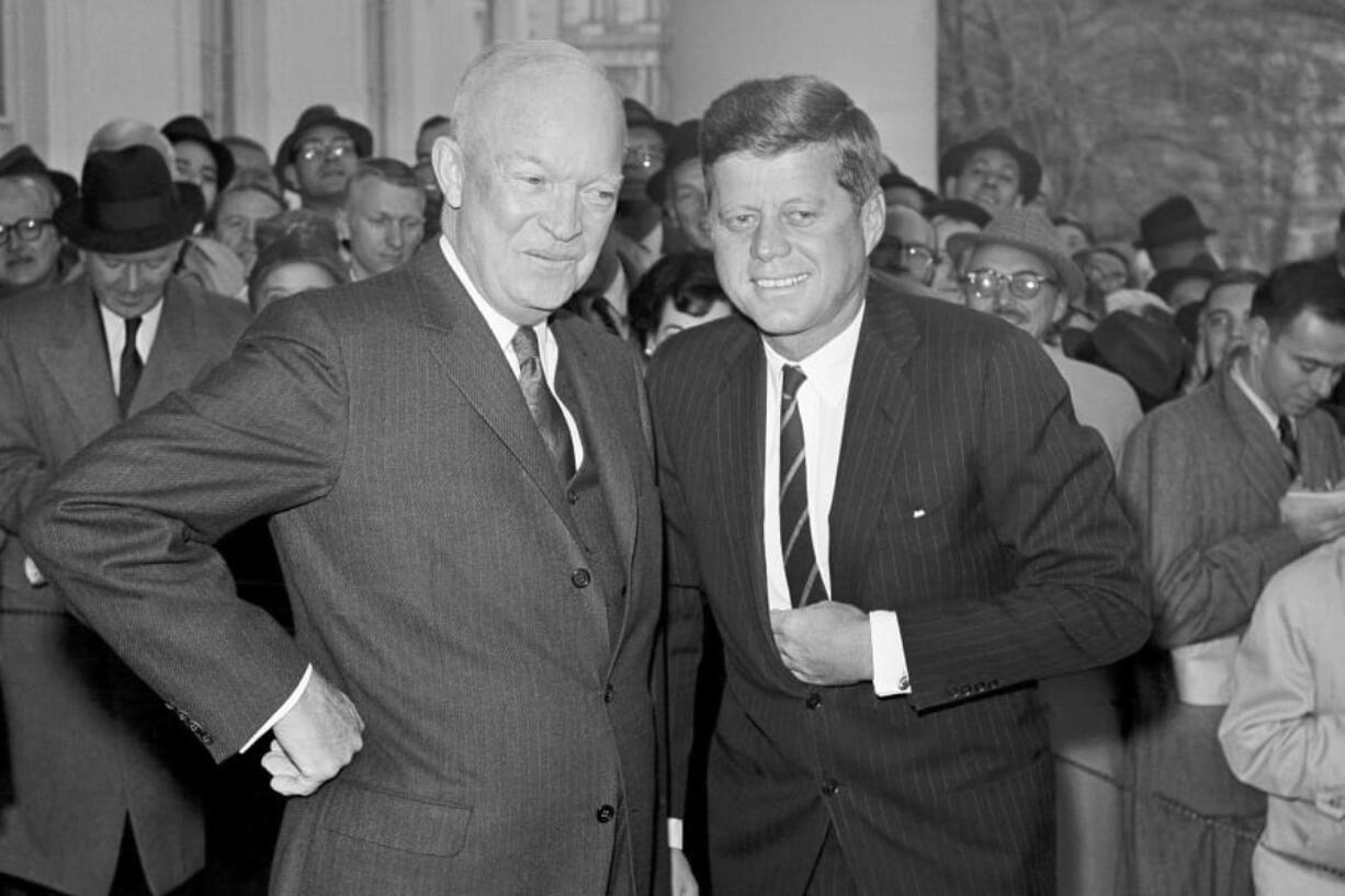 President Dwight Eisenhower poses with President-elect John F. Kennedy at the White House in Washington, before a private conference Dec. 6, 1960.