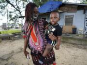 Fakisha Fenderson and her son Tyler stand in the front yard of her parent&#039;s home in Laurel, Miss., Monday, Aug. 31, 2020. Fenderson&#039;s weekly unemployment allotment is under $100, effectively eliminating her chance at receiving the $300 weekly supplement proposed by President Trump&#039;s executive order. (AP Photo/Rogelio V. Solis) (rogelio v.