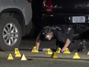 A Washington State Patrol Crime Lab worker looks at evidence markers in the early morning hours of Sept. 4 in Lacey, at the scene where Michael Reinoehl was killed as investigators moved in to arrest him. (Ted S.