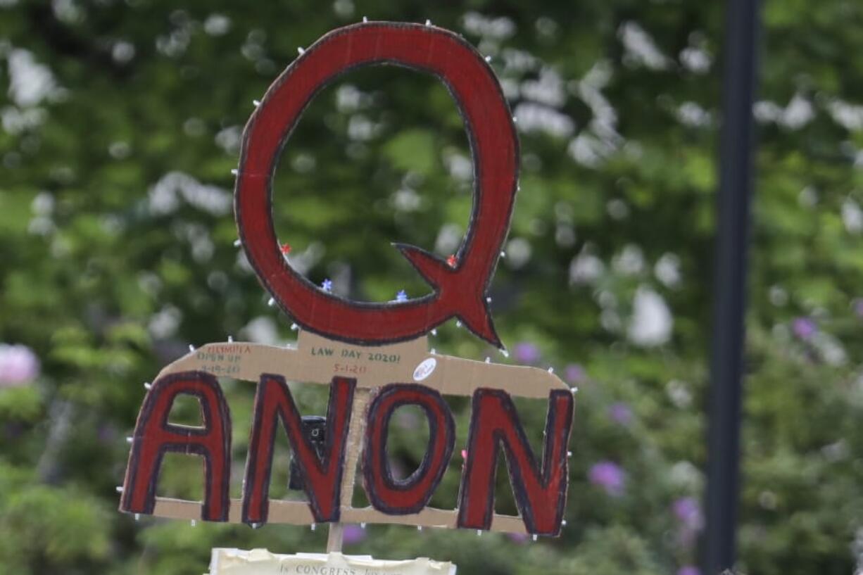 A person carries a sign supporting QAnon at a May 14 protest rally in Olympia.  (AP Photo/Ted S.