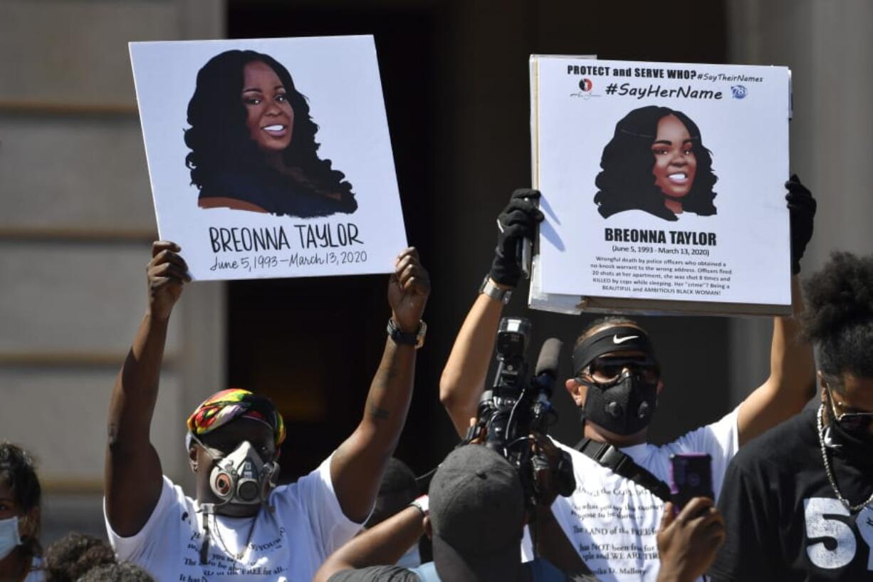 FILE - Signs are held up showing Breonna Taylor during a rally in her honor on the steps of the Kentucky State Capitol in Frankfort, Ky., Thursday, June 25, 2020. The city of Louisville will pay several million dollars to the mother of Breonna Taylor and install police reforms as part of a settlement of a lawsuit from Taylor&#039;s family, The Associated Press has learned. (AP Photo/Timothy D.