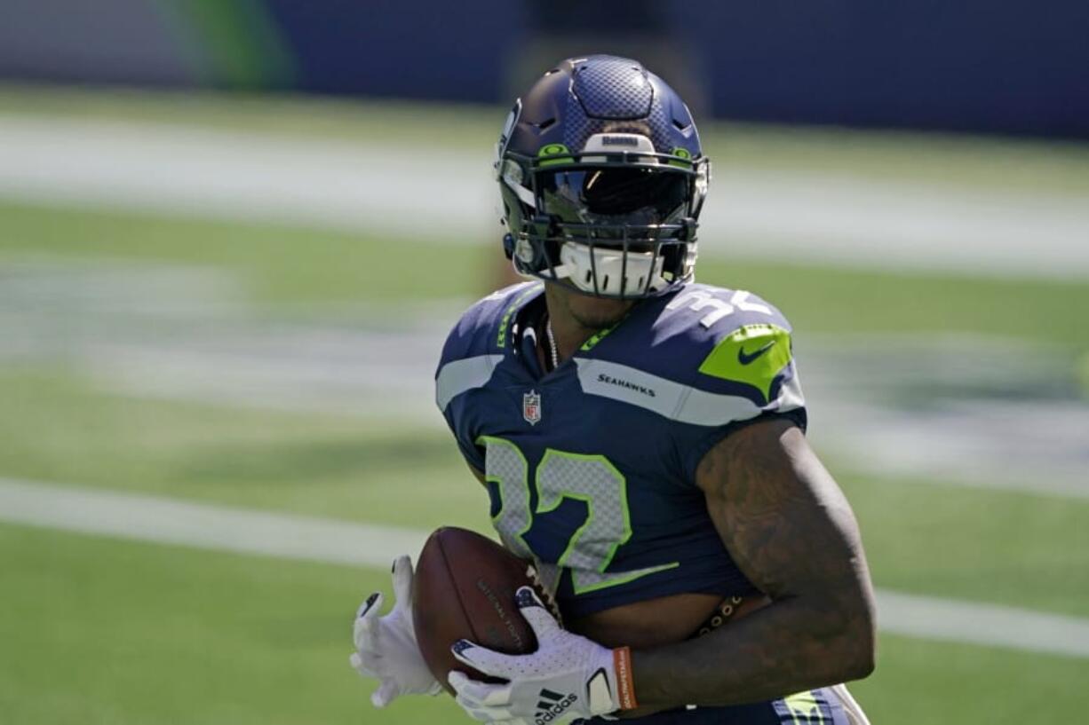 Seattle Seahawks running back Chris Carson holds the football as players warm up for an NFL football scrimmage Wednesday, Aug. 26, 2020, in Seattle. (AP Photo/Ted S.