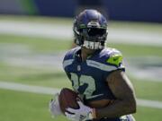 Seattle Seahawks running back Chris Carson holds the football as players warm up for an NFL football scrimmage Wednesday, Aug. 26, 2020, in Seattle. (AP Photo/Ted S.