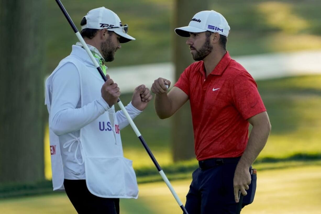 Matthew Wolff, right, bumps fists with his caddie after finishing the third round of the US Open Golf Championship, Saturday, Sept. 19, 2020, in Mamaroneck, N.Y.