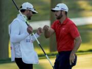 Matthew Wolff, right, bumps fists with his caddie after finishing the third round of the US Open Golf Championship, Saturday, Sept. 19, 2020, in Mamaroneck, N.Y.