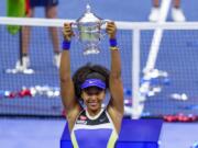 Naomi Osaka, of Japan, holds up the championship trophy after defeating Victoria Azarenka, of Belarus, in the women&#039;s singles final of the US Open tennis championships, Saturday, Sept. 12, 2020, in New York.