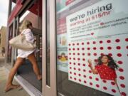 FILE - In this Sept. 2, 2020, file photo, a help wanted sign hangs on the door of a Target store in Uniontown, Pa. Hundreds of thousands of Americans likely applied for unemployment benefits last week, a high level of job insecurity that reflects economic damage from the coronavirus outbreak. Economists expect that 850,000 people sought jobless aid, down from 884,000 the week before, according to a survey by the data firm FactSet. (AP Photo/Gene J.