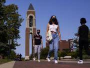 Masked students walk through the campus of Ball State University in Muncie, Ind., Thursday, Sept. 10, 2020. College towns across the U.S. have emerged as coronavirus hot spots in recent weeks as schools struggle to contain the virus. Out of nearly 600 students tested for the virus at Ball State, more than half have returned been found positive, according to data reported by the school. Dozens of infections have been blamed on off-campus parties, prompting university officials to admonish students.