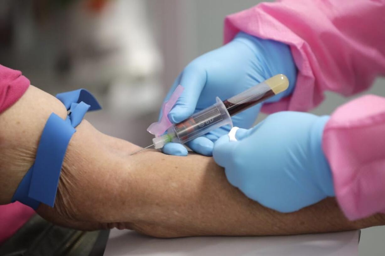 FILE - In this Tuesday, May 5, 2020 file photo, a health worker draws blood from a patient for a COVID-19 coronavirus antibody test in DeLand, Fla. Scientists are still working to figure out how well antibodies for the new coronavirus may shield someone from another infection, or how long that protection might last.