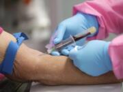 FILE - In this Tuesday, May 5, 2020 file photo, a health worker draws blood from a patient for a COVID-19 coronavirus antibody test in DeLand, Fla. Scientists are still working to figure out how well antibodies for the new coronavirus may shield someone from another infection, or how long that protection might last.