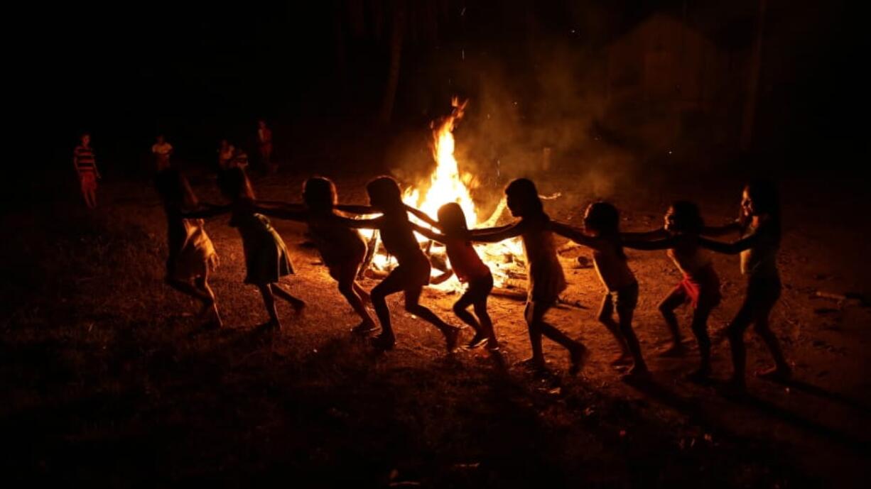 Tenetehara Indigenous children play around a campfire during a festival in the Alto Rio Guama Indigenous Reserve, where they have enforced six months of isolation during the new coronavirus pandemic, near the city of Paragominas, Brazil, Monday, Sept. 7, 2020. The Indigenous group, also known as Tembe, are celebrating and giving thanks that none of their members have fallen ill with COVID-19.