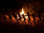 Tenetehara Indigenous children play around a campfire during a festival in the Alto Rio Guama Indigenous Reserve, where they have enforced six months of isolation during the new coronavirus pandemic, near the city of Paragominas, Brazil, Monday, Sept. 7, 2020. The Indigenous group, also known as Tembe, are celebrating and giving thanks that none of their members have fallen ill with COVID-19.