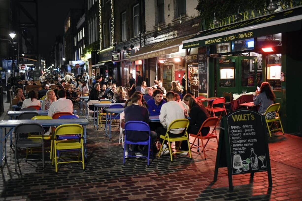 People eat and drink outside in Soho, in London, Tuesday, Sept. 22, 2020. Britain&#039;s Prime Minister, Boris Johnson, has announced that pubs and restaurants closing at 10pm, due to the spike of cases of coronavirus across the United Kingdom.