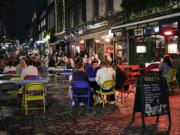 People eat and drink outside in Soho, in London, Tuesday, Sept. 22, 2020. Britain&#039;s Prime Minister, Boris Johnson, has announced that pubs and restaurants closing at 10pm, due to the spike of cases of coronavirus across the United Kingdom.