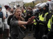 Riot police face protesters who took part in a &#039;We Do Not Consent&#039; rally at Trafalgar Square, organised by Stop New Normal, to protest against coronavirus restrictions, in London, Saturday, Sept. 26, 2020.