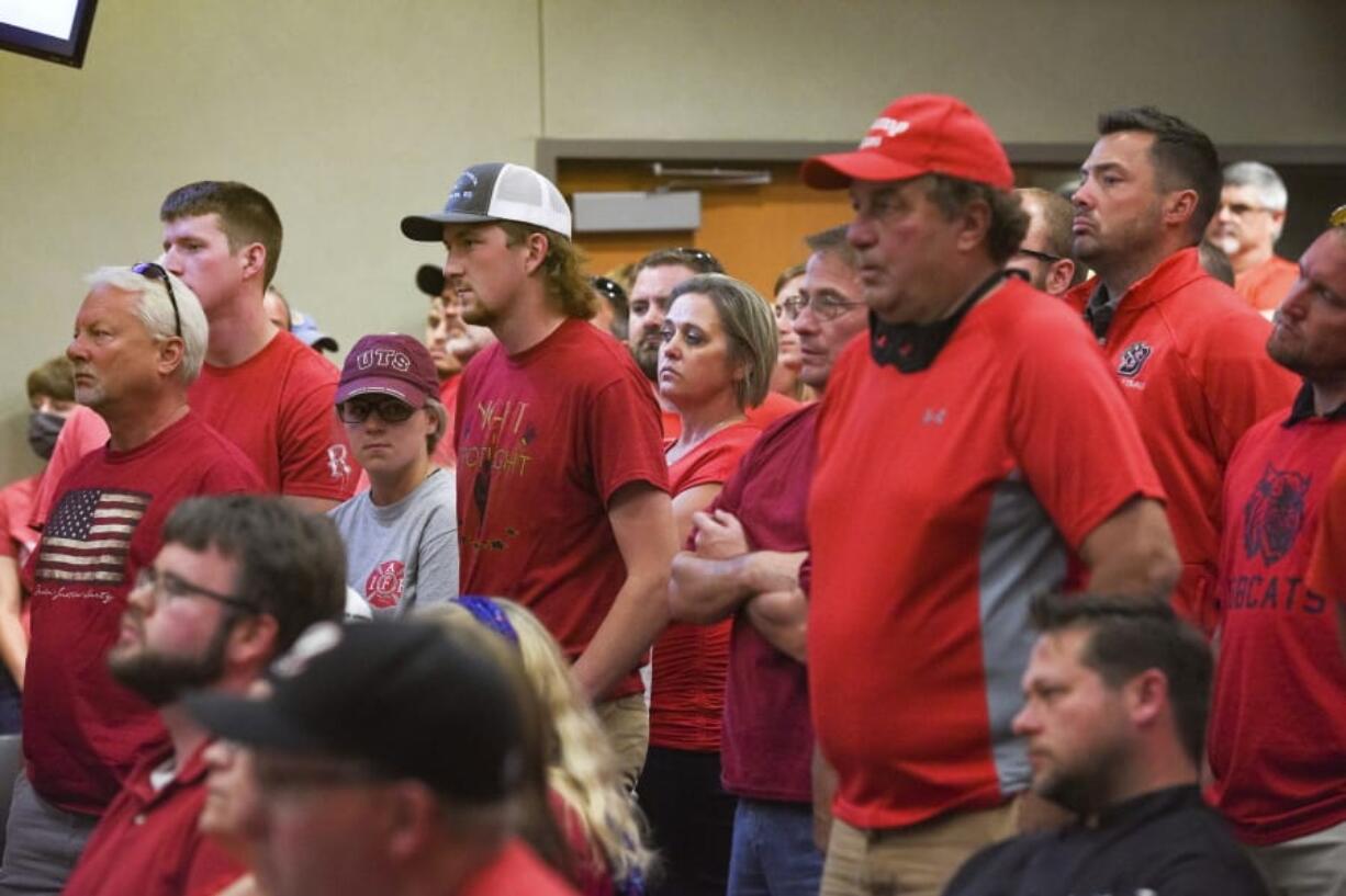 People wear red in solidarity against a potential city-wide mask mandate during a city council meeting on Wednesday, Sept. 2, 2020, in Brookings, S.D. Coronavirus infections in the Dakotas are growing faster than anywhere else in the nation, fueling impassioned debates over masks, personal responsibility and freedom after months in which the two states avoided the worst of the pandemic.