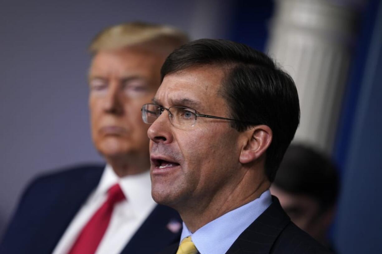 FILE - In this March 18, 2020, file photo, Defense Secretary Mark Esper speaks as President Donald Trump listens during press briefing with the coronavirus task force, at the White House in Washington. The government&#039;s $3 trillion effort to rescue the economy from the coronavirus crisis is stirring worry at the Pentagon. Bulging federal deficits may force a reversal of years of big defense spending gains and threaten prized projects like the rebuilding of the nation&#039;s arsenal of nuclear weapons. Esper says the sudden burst of emergency spending to prop up a stalled economy is bringing the Pentagon closer to a point where it will have to shed older weapons faster and tighten its belt.